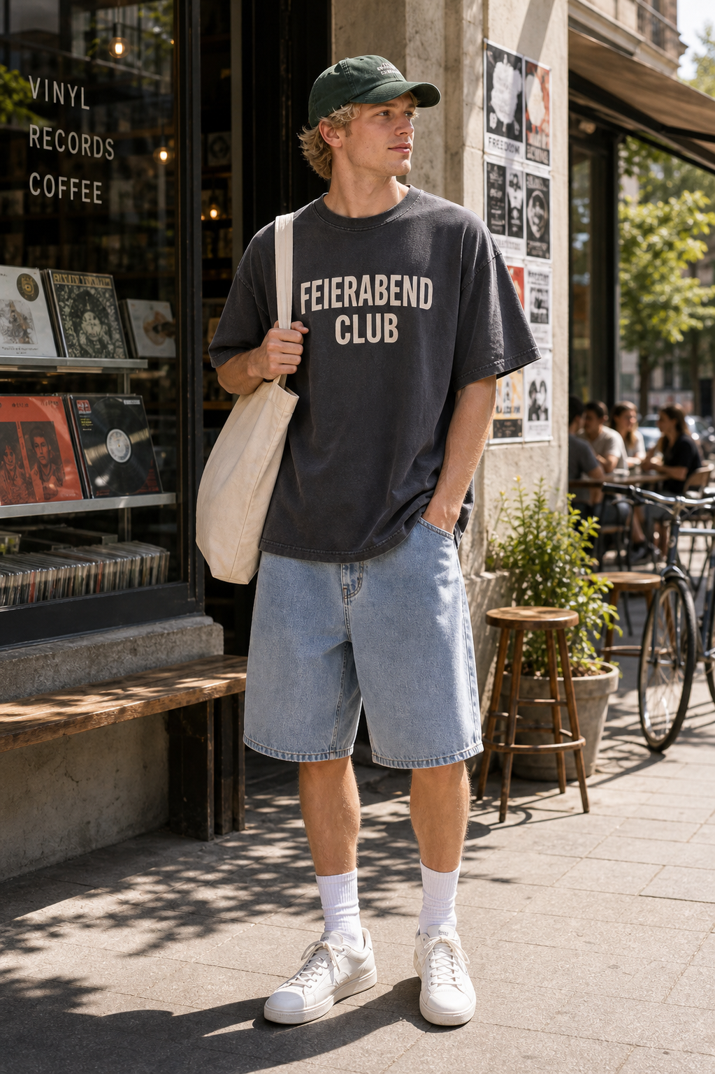 Germany Feierabend Club graphic set sunny model scene with charcoal tee green cap natural canvas tote and washed shorts